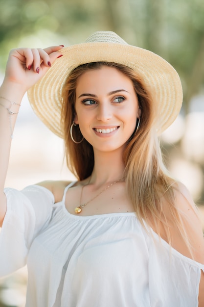 Portrait of young beautiful smiling woman in summer park