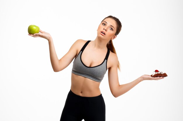 Portrait of young beautiful sportive girl over white background.