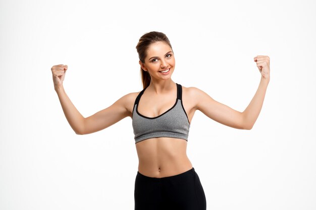 Portrait of young beautiful sportive girl over white background.