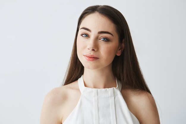 Portrait of young beautiful tender girl in blouse smiling .