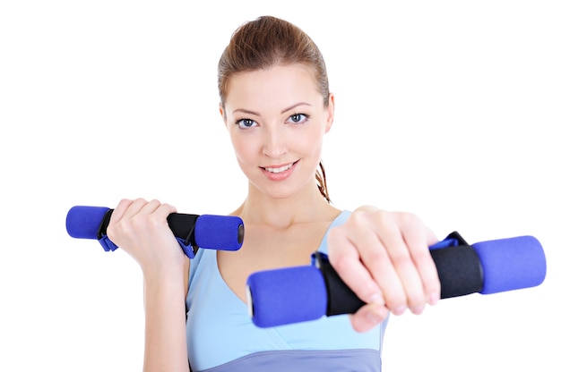 Portrait of young beautiful woman doing physical exercises with dumbbells