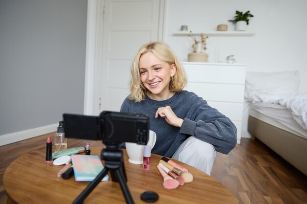portrait of young beautiful woman lifestyle blogger talking about makeup on camera recording vlog