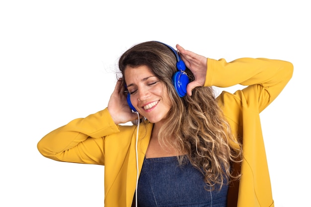 Портрет молодой красивой женщины, слушающей музыку с синими наушниками