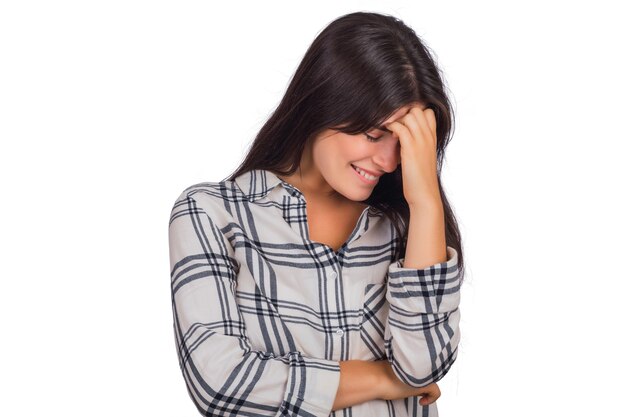 Portrait of young beautiful woman looking shy hiding behind her hand and smiling