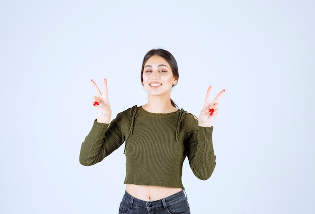 Portrait of a young beautiful woman model showing her fingers