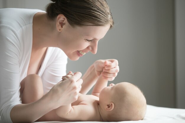 Portrait of a young beautiful woman playing with a newborn