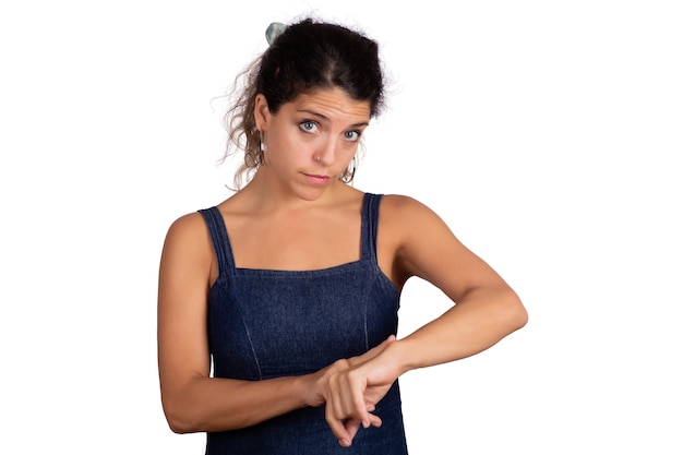 Portrait of young beautiful woman pointing finger on wrist