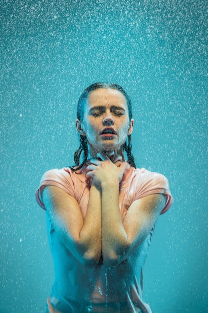 Free photo the portrait of young beautiful woman in the rain