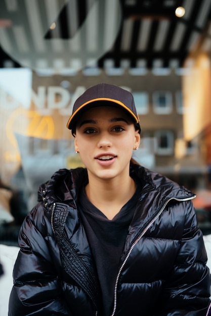 Free photo portrait of young beautiful woman sitting in a cafe outdoor drinking coffee