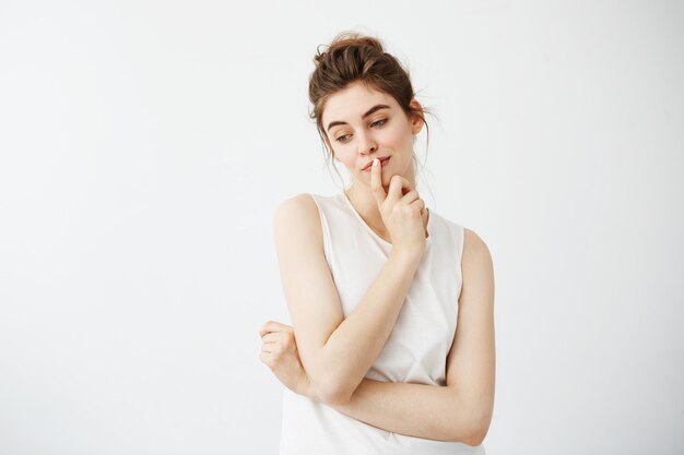 Portrait of young beautiful woman smiling thinking dreaming touching her chin