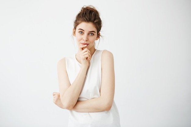 Portrait of young beautiful woman smiling touching her chin.