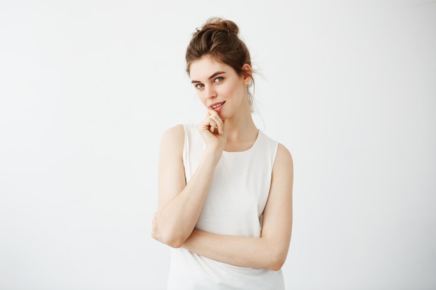 Portrait of young beautiful woman smiling touching her chin.