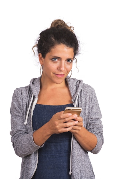 Portrait of young beautiful woman using her mobile phone in studio. Isolated white background. Technology and communication concept.