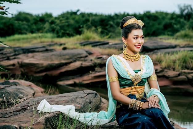 Foto gratuita ritratto di giovane bella donna che indossa in costume tradizionale con ornamento in posa nella natura in thailandia