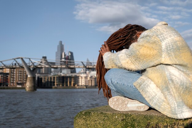 Portrait of young beautiful woman with afro dreadlocks in the city