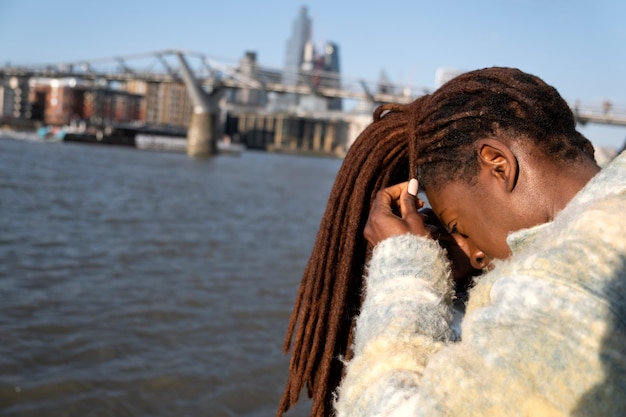 Portrait of young beautiful woman with afro dreadlocks in the city