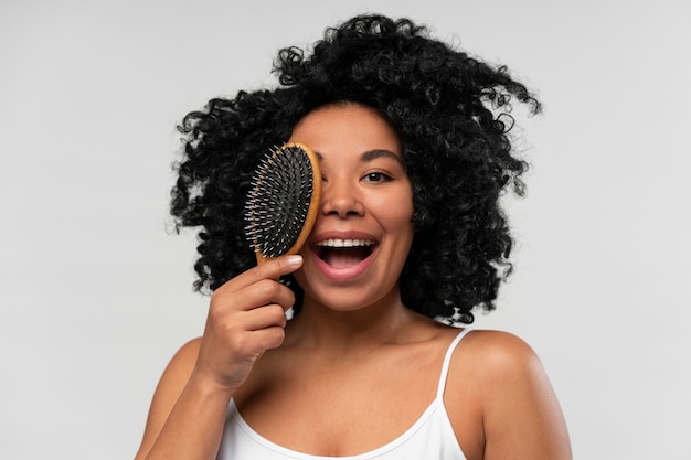 Portrait of young beautiful woman with hairbrush