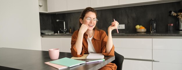 portrait of young beautiful woman with pen writing student studying at home doing homework making