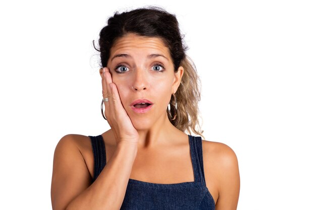 Portrait of young beautiful woman with shocked expression isolated against white background.