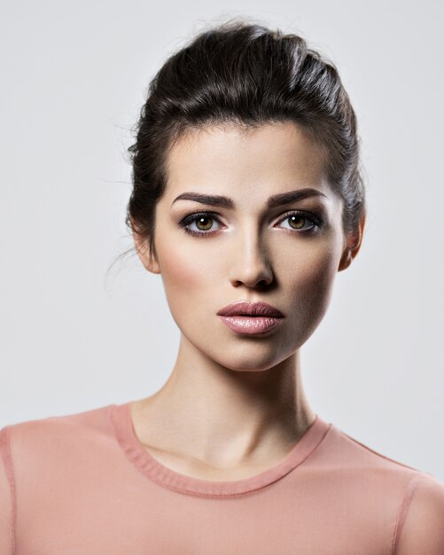 Portrait of an young beautiful  woman with  smoky eyes makeup. Pretty young adult girl posing at studio. Closeup attractive female face.