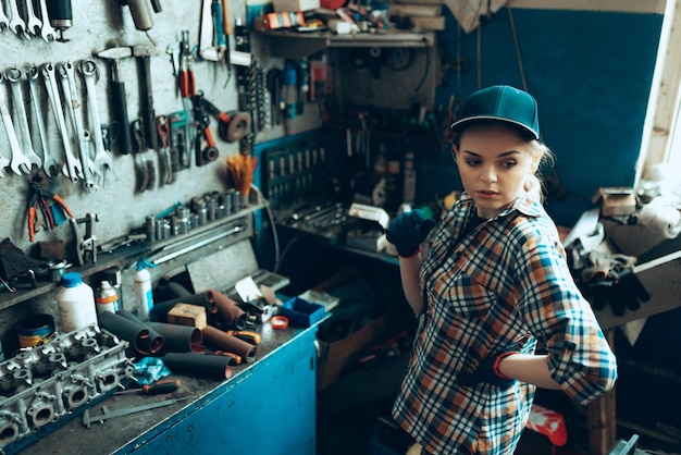 Free photo portrait of young beautiful woman working as auto mechanic at auto service indoors gender equality work occupation job