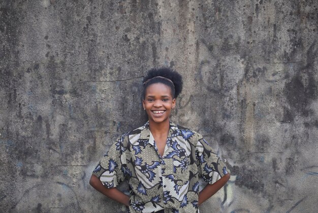 portrait of young black woman leaning against a wall