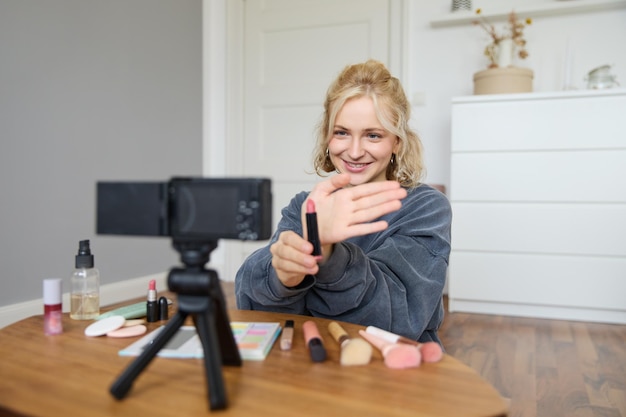 Foto gratuita ritratto di una giovane donna bionda adolescente che registra un video per il suo account sui social media e mostra il trucco