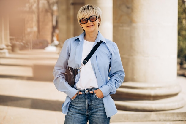 Free photo portrait of young blonde woman posing in the street