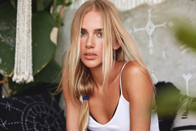 Portrait of young blonde woman sits on a cafe