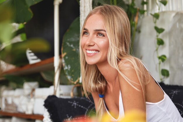 Portrait of young blonde woman sits on a cafe