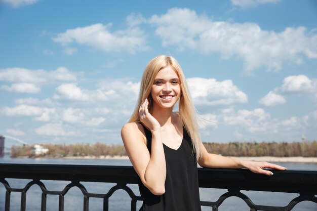 Портрет молодой блондинки, стоя возле реки