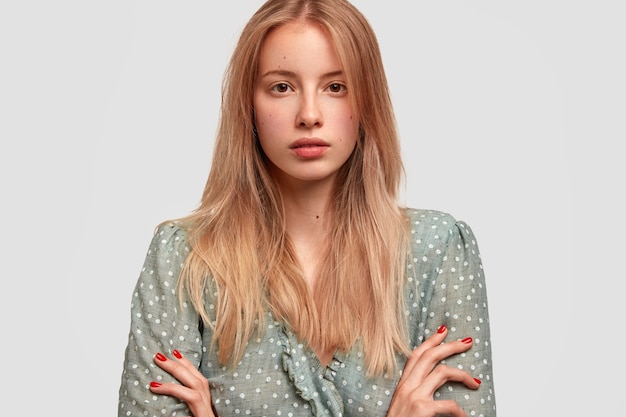 Portrait of young blonde woman in stylish blouse