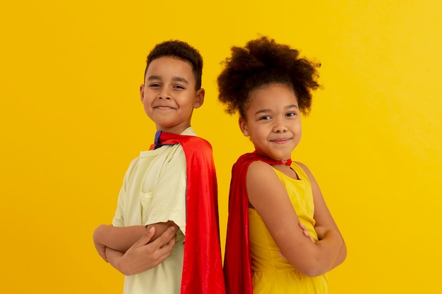 Portrait of young boy and girl with superhero capes