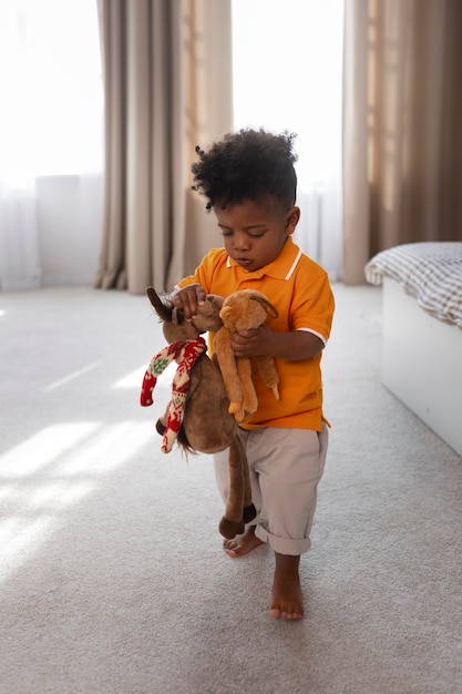 Free photo portrait of young boy playing with his stuffed animal toy