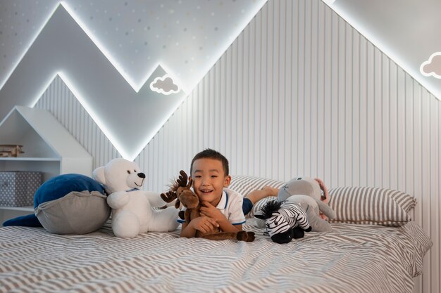 Free photo portrait of young boy playing with his stuffed animal toy