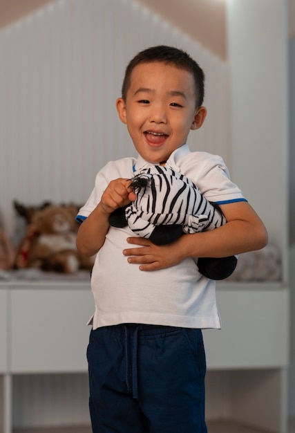 Free photo portrait of young boy playing with his stuffed animal toy
