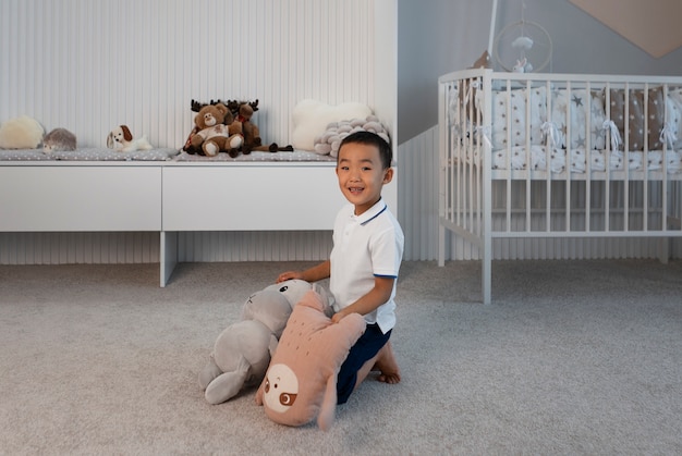 Free photo portrait of young boy playing with his stuffed animal toy