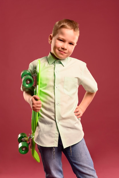 Ritratto di giovane ragazzo in posa con lo skateboard