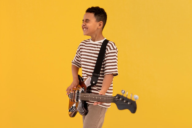 Free photo portrait of young boy with guitar