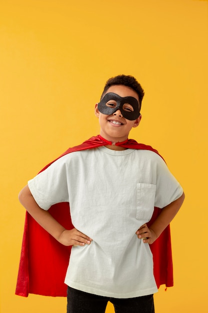 Foto gratuita ritratto di giovane ragazzo con mantello da supereroe