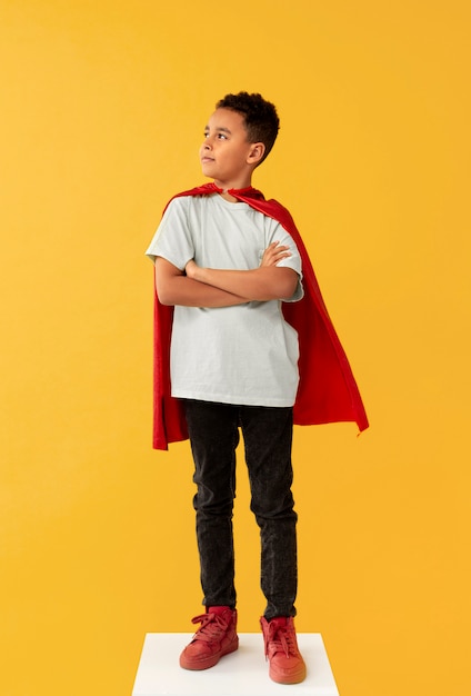 Free photo portrait of young boy with superhero cape