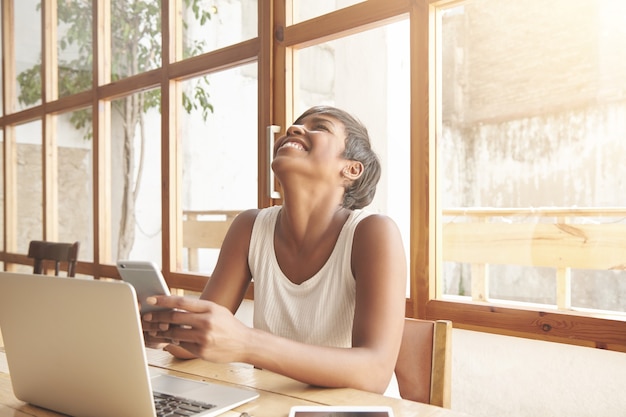 Free photo portrait of young brunette woman sitting in cafe with laptop