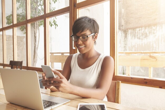 Portrait of young brunette woman sitting in cafe with laptop