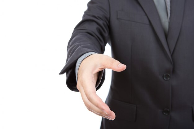 Portrait of young business man extending hand to shake against w