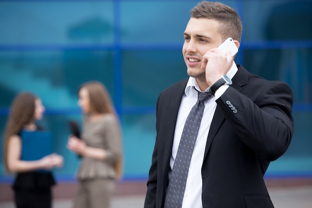 Portrait of young business man talking on phone outdoor