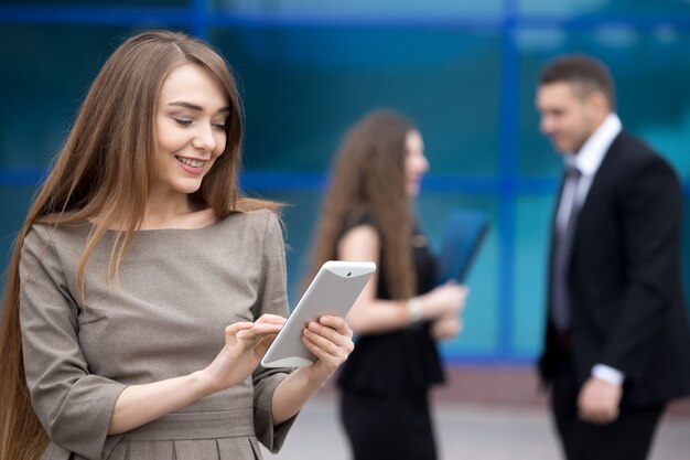 Portrait of young business woman looking at tablet screen