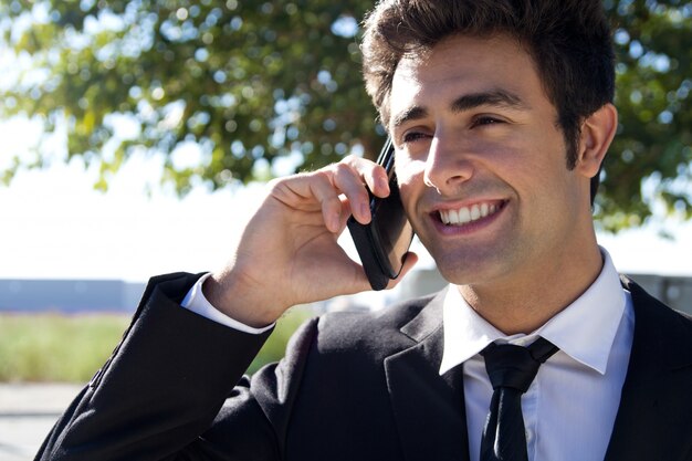 Портрет молодого бизнесмена говорить со смартфоном