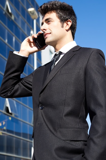 Portrait of young businessman talking with smartphone