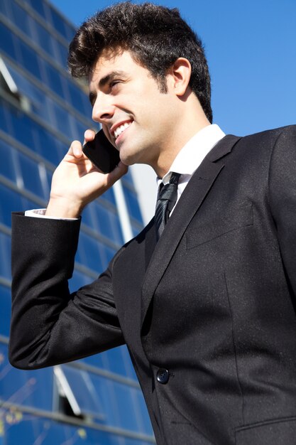 Портрет молодого бизнесмена говорить со смартфоном