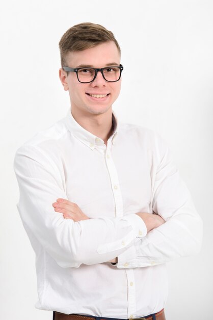 Portrait of a young businessman with arms crossed looking to camera isolated against white background